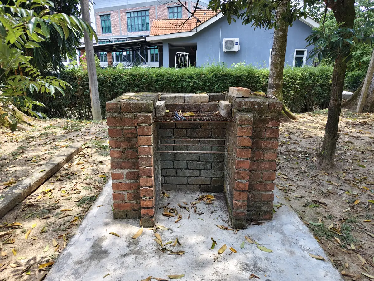 Dapur barbeku bata di luar, atas pasir di bawah pokok