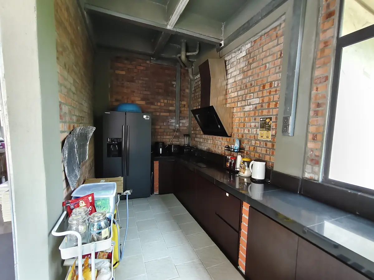 Kaunter dapur panjang dengan peti sejuk dan dinding bata